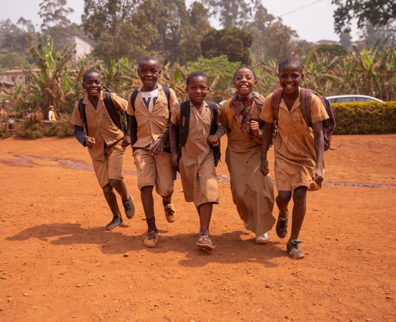 Young group of african children all together at school yard having fun playing holding hands